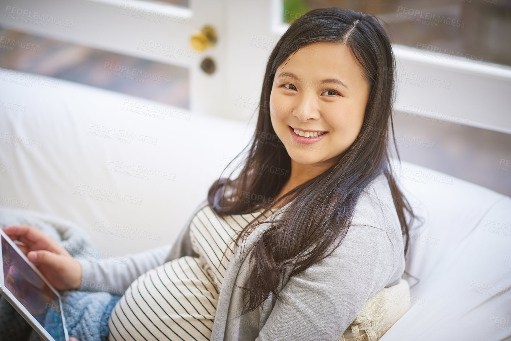 Buy stock photo Portrait of a pregnant woman using a digital tablet at home