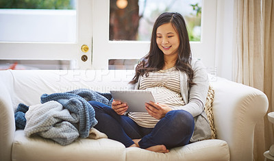 Buy stock photo Shot of a pregnant woman using a digital tablet at home