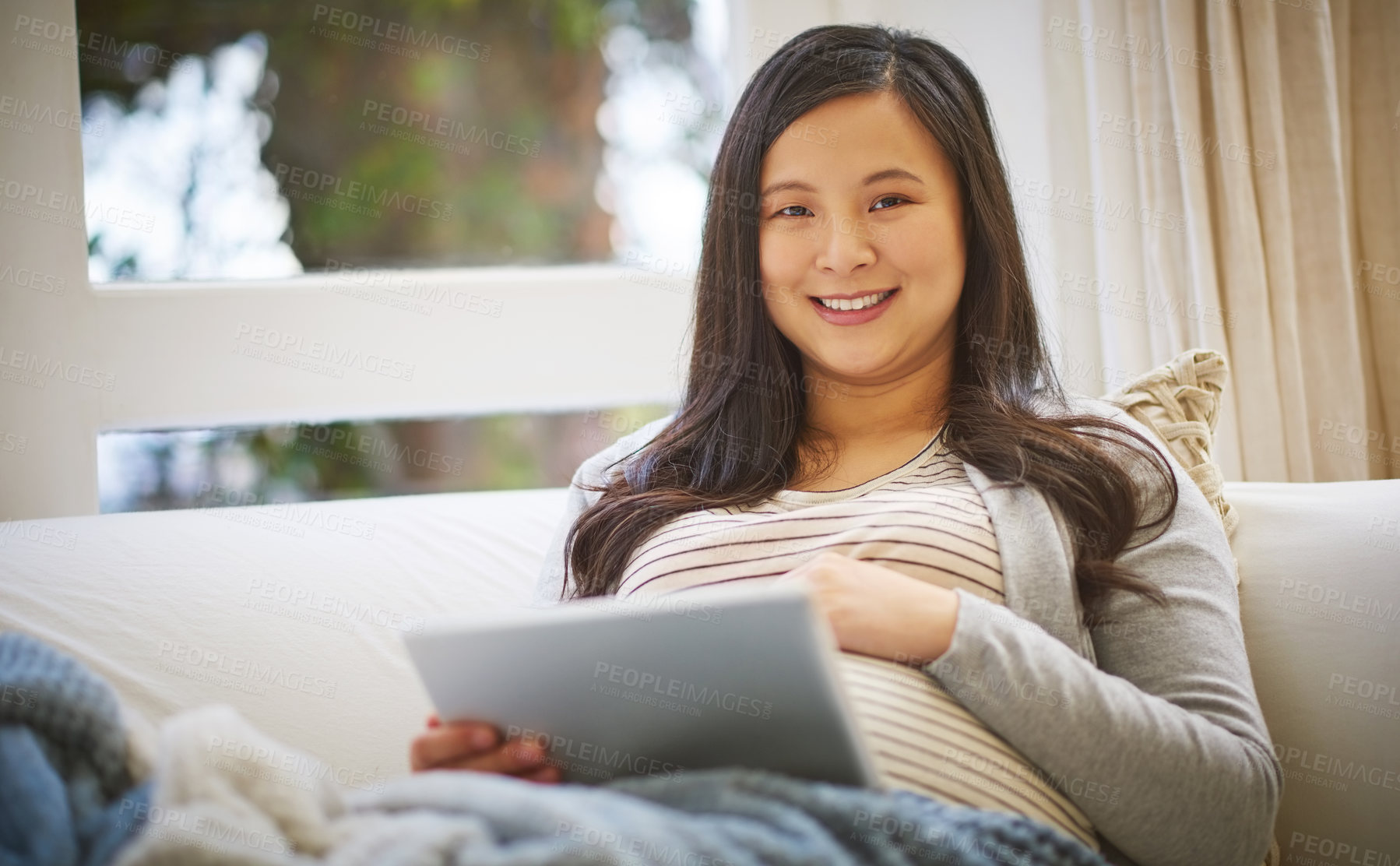 Buy stock photo Portrait of a pregnant woman using a digital tablet at home