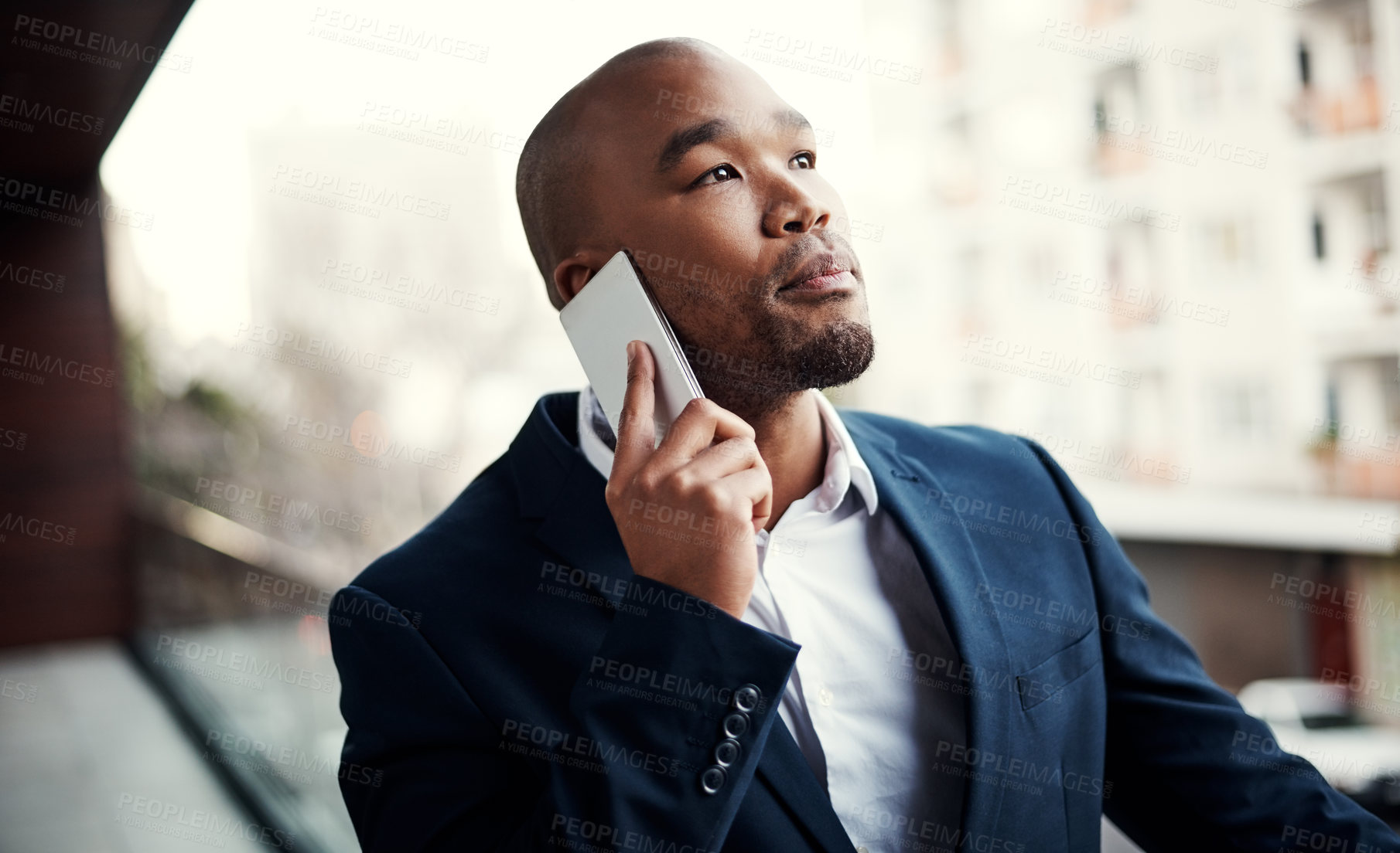 Buy stock photo Shot of a handsome young businessman talking on a cellphone outside his office