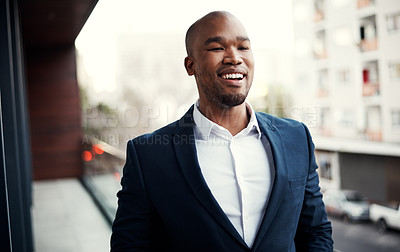Buy stock photo Shot of a handsome young businessman standing outside on his office balcony