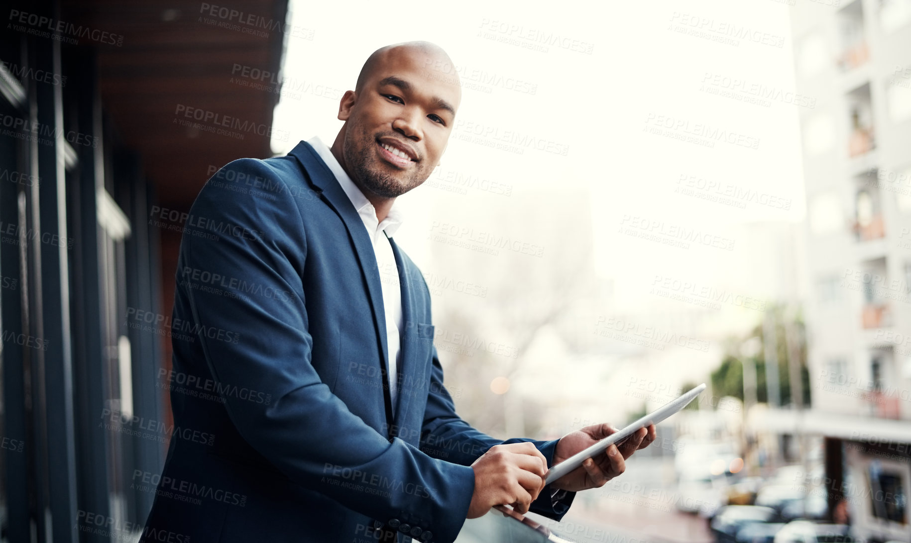 Buy stock photo Portrait of a handsome young businessman using a digital tablet outside his office