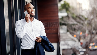 Buy stock photo Shot of a handsome young businessman talking on a cellphone outside his office