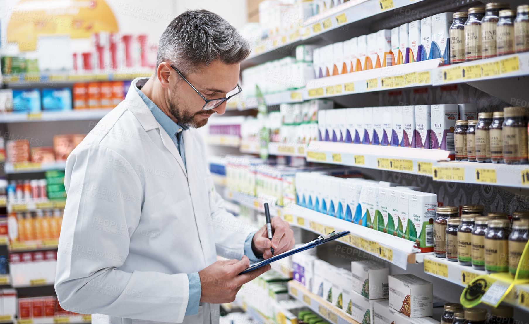 Buy stock photo Shot of a mature pharmacist doing inventory in a pharmacy