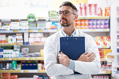 Buy stock photo Shot of a confident mature pharmacist working in a pharmacy