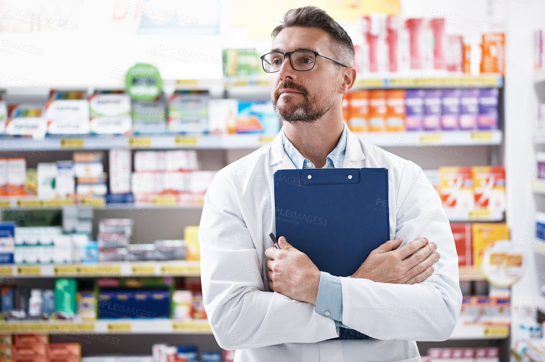 Buy stock photo Shot of a confident mature pharmacist working in a pharmacy