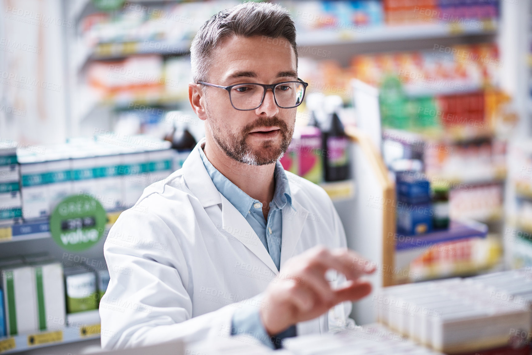 Buy stock photo Shot of a mature pharmacist doing inventory in a pharmacy