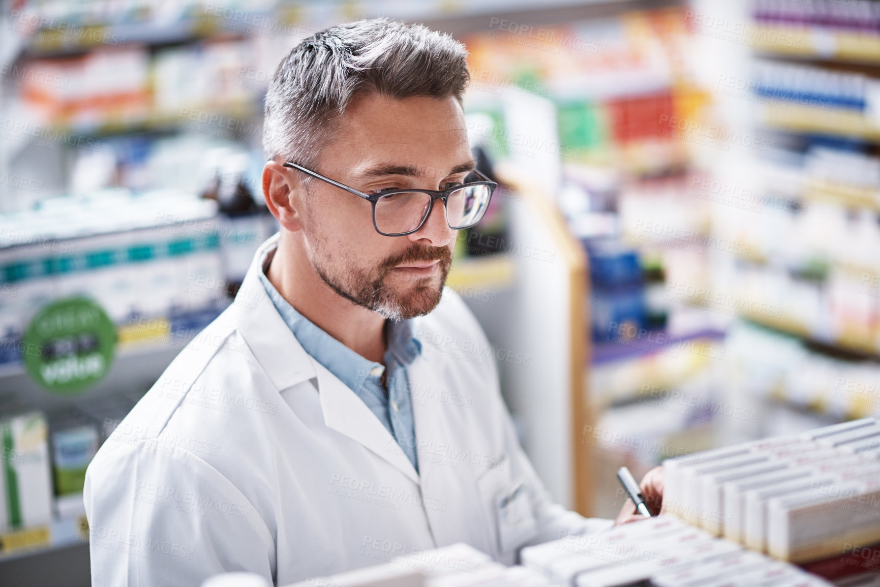 Buy stock photo Shot of a mature pharmacist doing inventory in a pharmacy