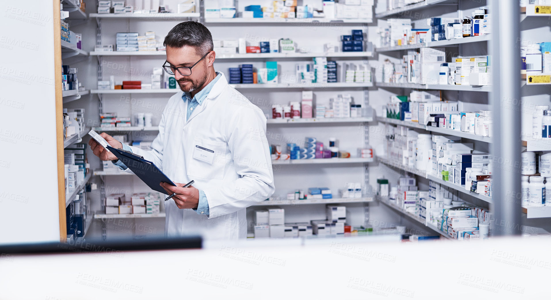 Buy stock photo Shot of a mature pharmacist doing inventory in a pharmacy