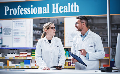 Buy stock photo Shot of two pharmacists working in a pharmacy