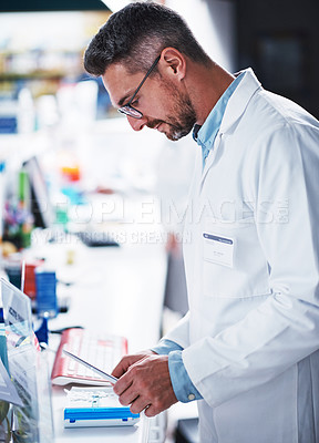 Buy stock photo Shot of a mature pharmacist sorting medication in a pharmacy