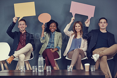 Buy stock photo Shot of a group of businesspeople holding up speech bubbles while waiting in line for an interview