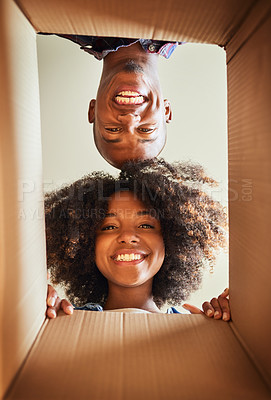 Buy stock photo Low angle portrait of a cheerful couple looking into a cardboard box at home during the day