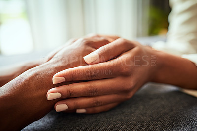 Buy stock photo Closeup of two unrecognizable people's hands holding each other while resting on top of a  table