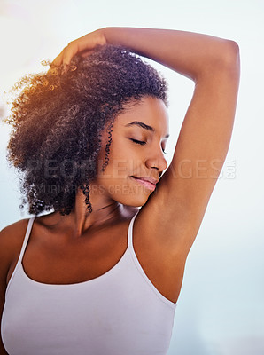 Buy stock photo Shot of an attractive young woman smelling her armpits during her morning beauty routine