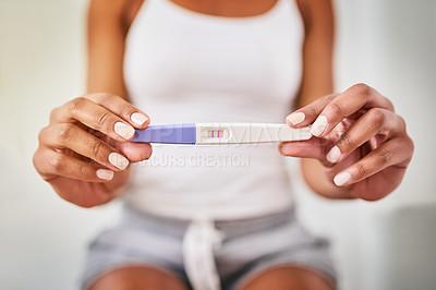 Buy stock photo Hands, woman and closeup of a positive pregnancy test by a woman in the bathroom of her home. Maternity, motherhood and zoom of a female person with a pregnant device in her modern house or apartment