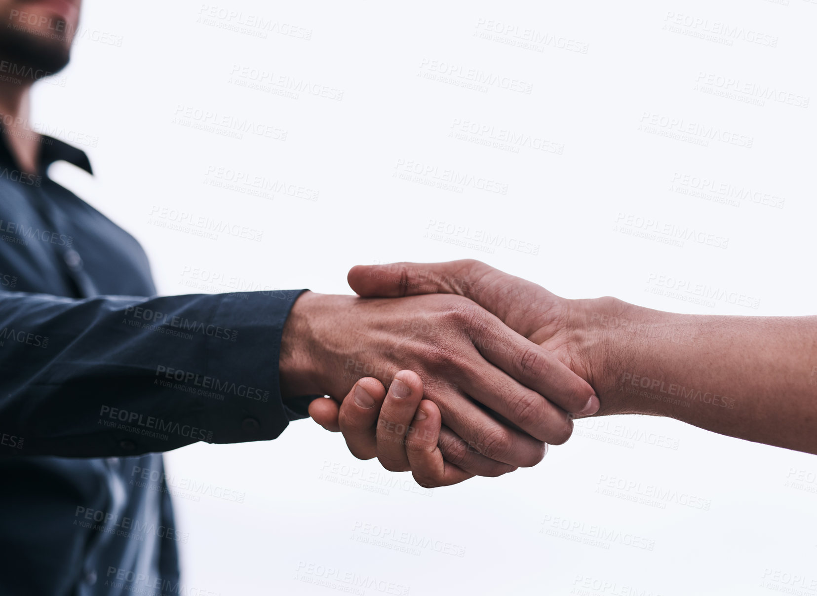 Buy stock photo Closeup shot of two unrecognizable businessmen shaking hands against a white background