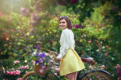 Buy stock photo Portrait of an attractive young woman riding a bicycle outdoors