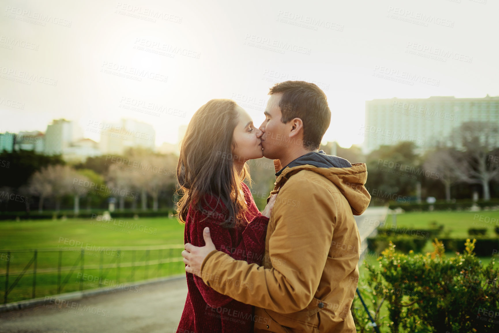 Buy stock photo Kiss, love and couple with park, date and smile for happy or romantic urban adventure. Bonding, man and woman with holiday, vacation or honeymoon together with summer tourist travel in city or town