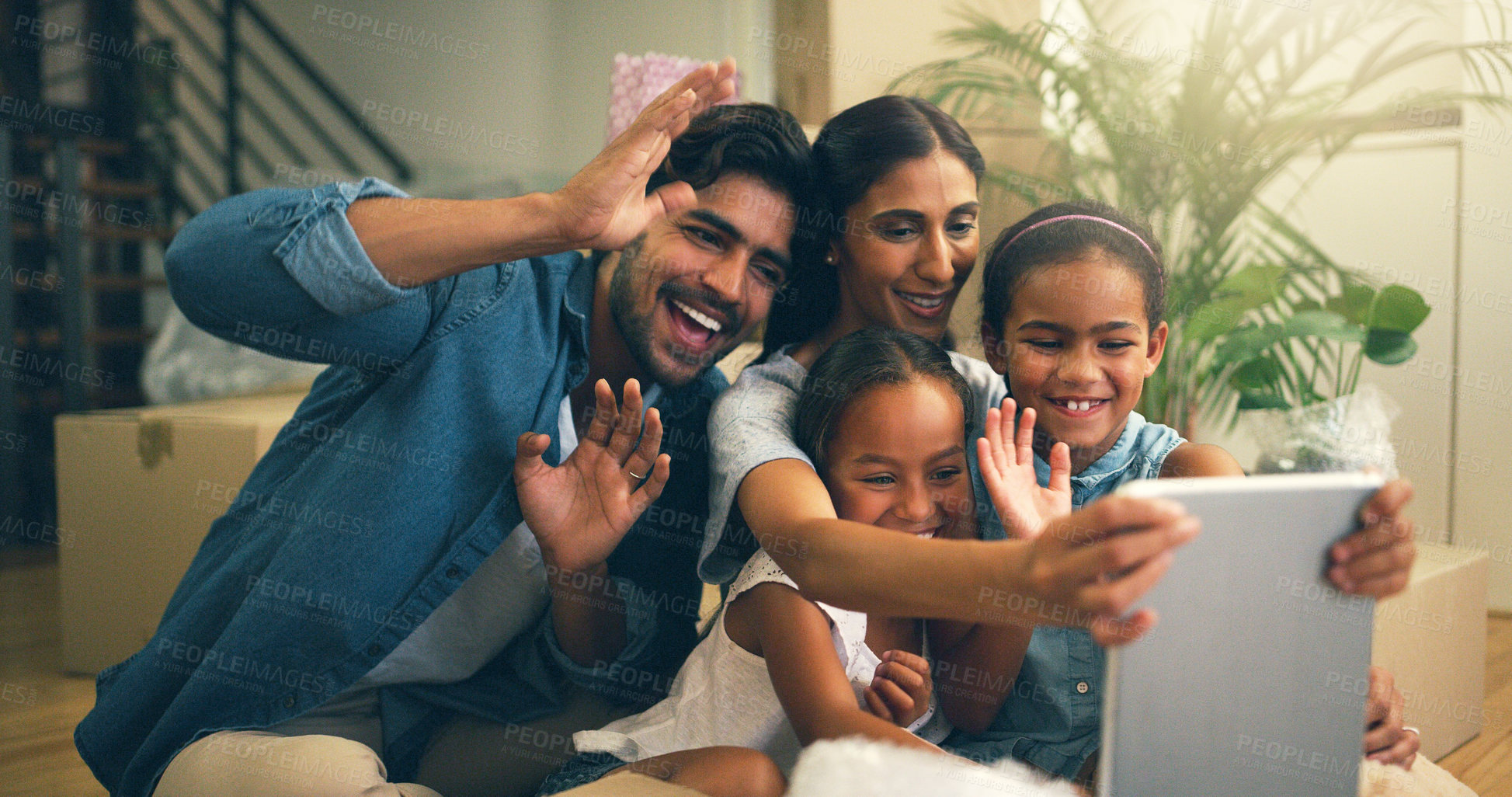 Buy stock photo Cropped shot of a young family making a video call on a tablet at home