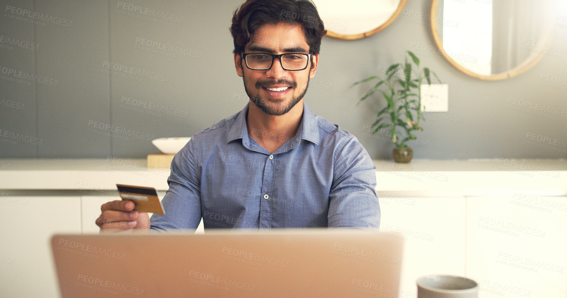 Buy stock photo Cropped shot of a handsome young businessman  making payments online and working at home