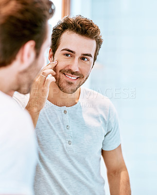 Buy stock photo Cropped shot of a handsome young man checking his face at home