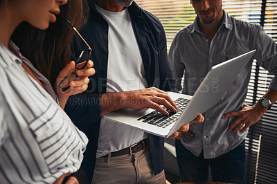 Buy stock photo Cropped shot of unrecognizable businesspeople working together and using a laptop in the office