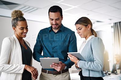 Buy stock photo Shot of a group of businesspeople working on a digital tablet in an office
