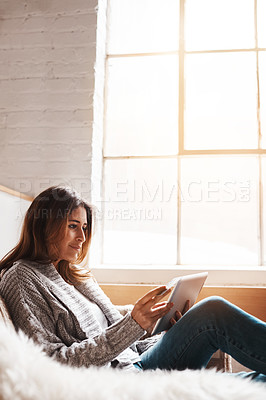 Buy stock photo Window, tablet and credit card with a woman online shopping on a sofa in the living room of her home. Ecommerce, finance and fintech banking with a young female user, customer or shopper in a house