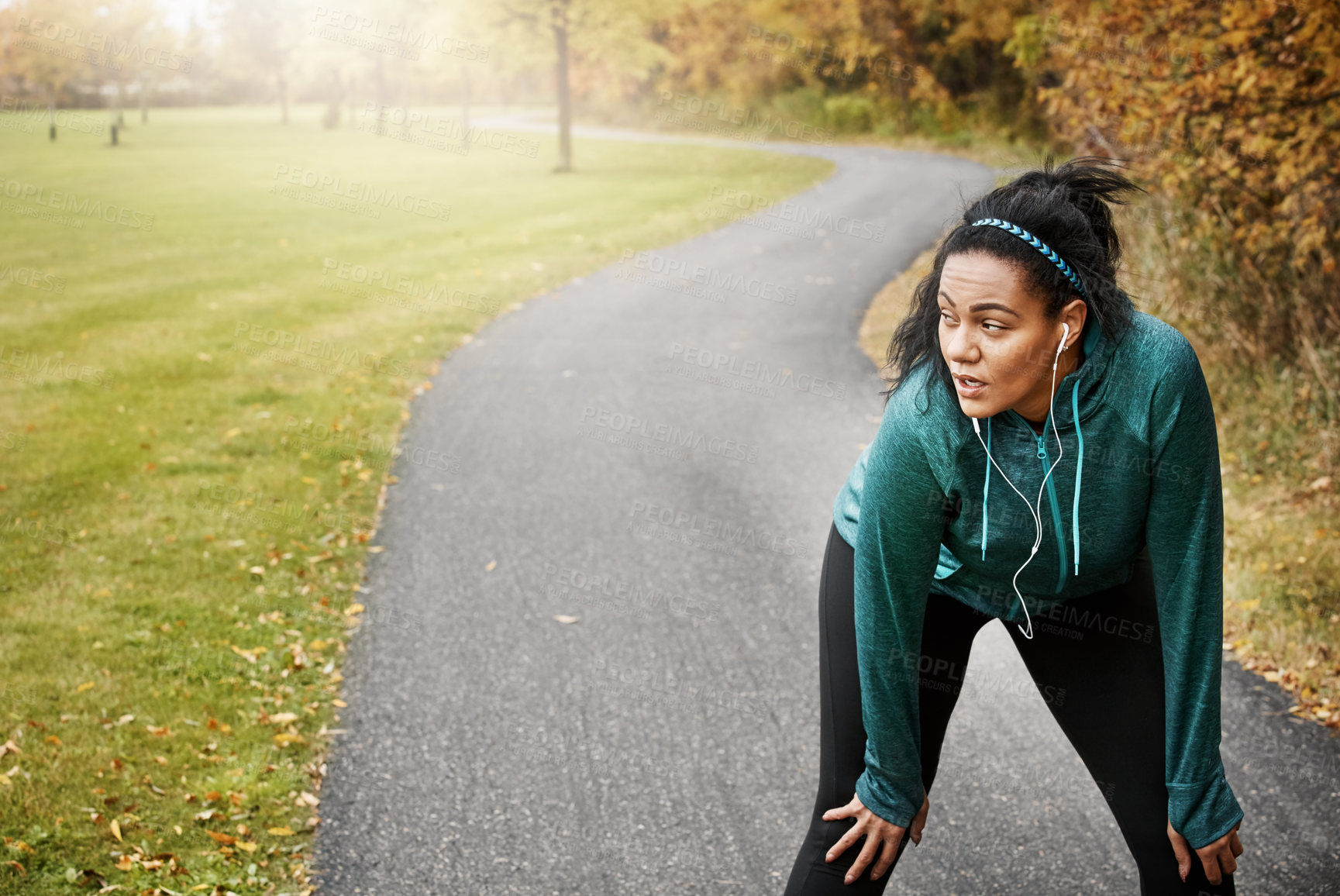 Buy stock photo Fitness, woman and rest in park with earphones, stop cardio workout or listening to music for recovery. Exhausted, female person and running break outdoor with audio tech, breathe and pause exercise.