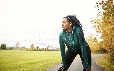 Buy stock photo Shot of an attractive young woman taking a break while out for a run in nature