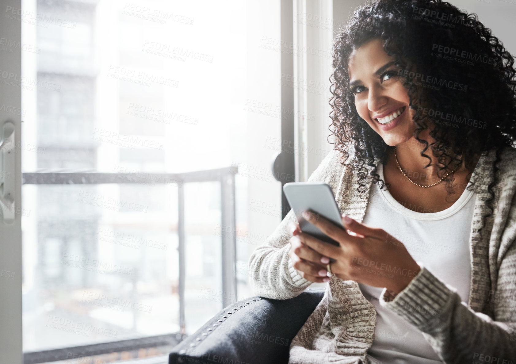 Buy stock photo Phone, happy and woman by window in home with networking, texting or social media on mobile app. Smile, technology and female person on sofa with cellphone for chatting online with contact in house.