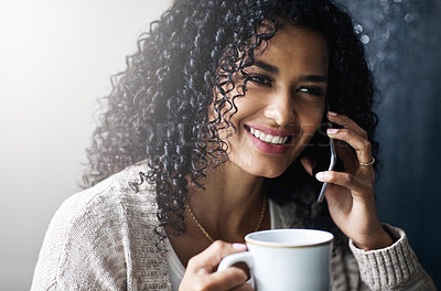 Buy stock photo Shot of a cheerful young woman relaxing and drinking coffee while talking on her cellphone at home during the day