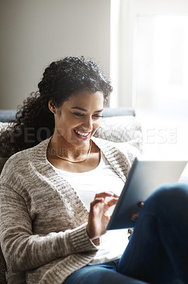 Buy stock photo Shot of an attractive young woman using a digital tablet at home