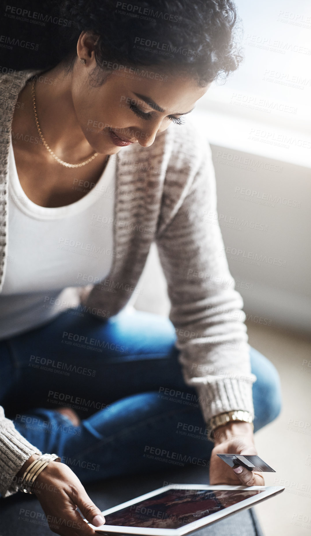 Buy stock photo Shot of an attractive young woman using a digital tablet at home