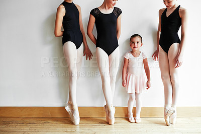 Buy stock photo Shot of a group of young ballerinas teaching a little girl ballet in a dance studio