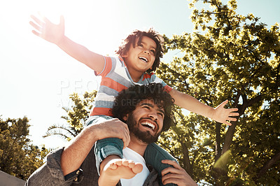 Buy stock photo Shot of a father giving his little son a piggyback ride outdoors