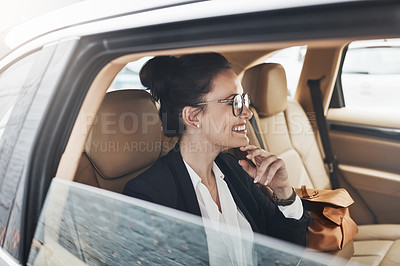 Buy stock photo Shot of a cheerful young businesswoman seated in a car as a passenger while on her way to work