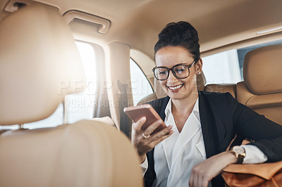Buy stock photo Shot of a confident young business woman seated in a car as a passenger and talking on her cellphone while  going to work