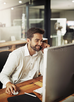 Buy stock photo Shot of a handsome young businessman talking on a cellphone while working late in an office