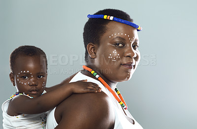 Buy stock photo Studio shot of a cheerful middle aged woman carrying her son on her back while standing against a grey background