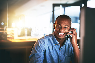 Buy stock photo Shot of a young businessman using a mobile phone during a late night in a modern office
