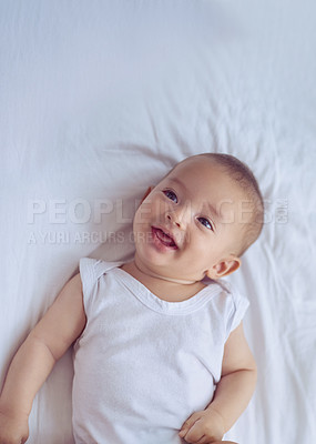 Buy stock photo High angle shot of an adorable baby boy lying down on a bed at home