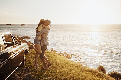 Buy stock photo Shot of an affectionate young couple enjoying a road trip along the coast