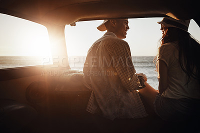 Buy stock photo Shot of an affectionate young couple enjoying a road trip along the coast