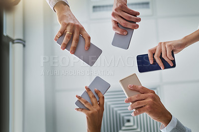 Buy stock photo Hands, smartphone and people networking on social media, mobile app or chatting together. Low angle, group and phone in circle for online network share, data sync or team communication survey