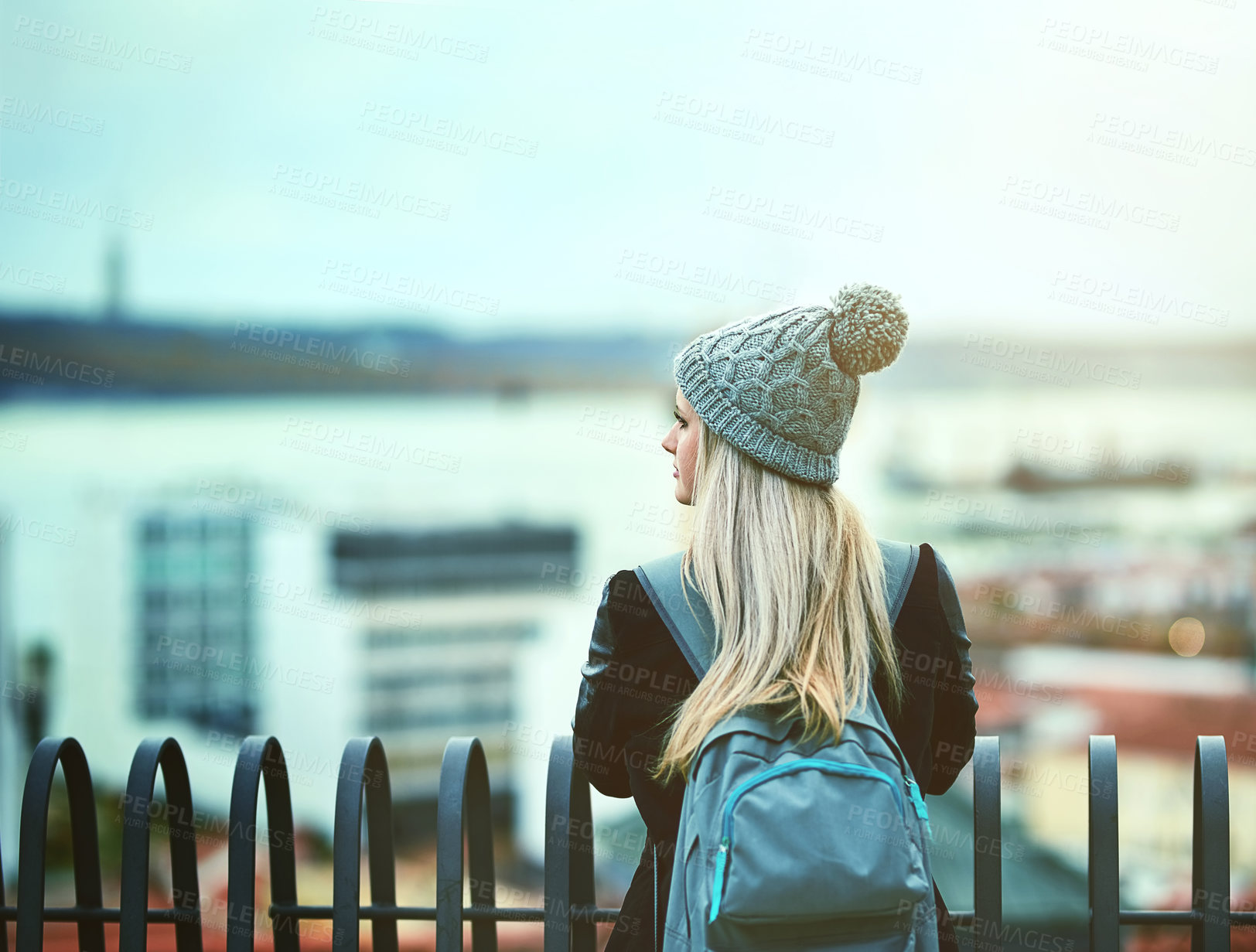 Buy stock photo Rearview shot of a young woman looking at the city view from a bridge
