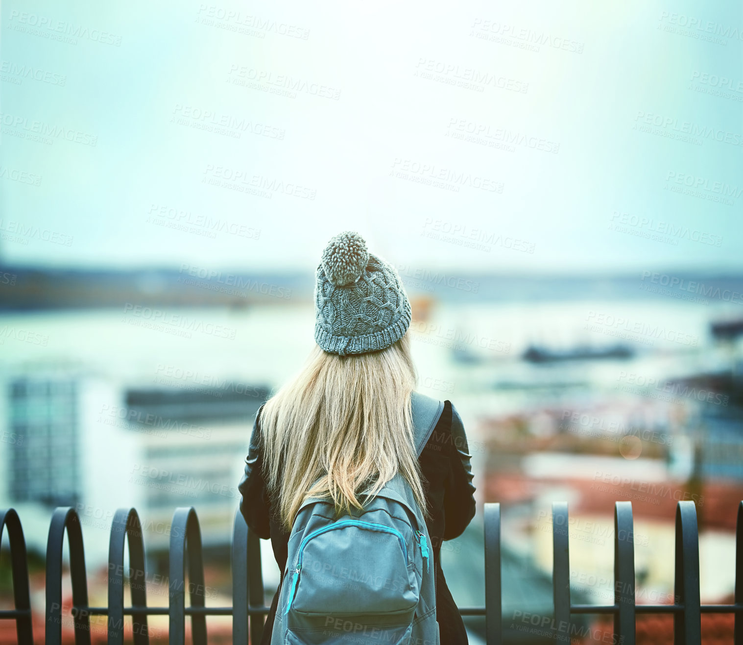 Buy stock photo Rearview shot of a young woman looking at the city view from a bridge