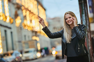 Buy stock photo Shot of an attractive woman using a mobile phone while calling a cab in the city