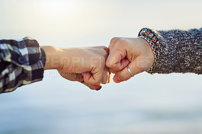 Buy stock photo Cropped shot of two unrecognizable women fist bumping outdoors